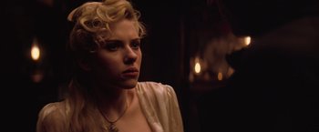 Movie still from “The Prestige” (2006), directed by Christopher Nolan – A woman with blonde curly hair wearing a white shirt; Close Up shot, Over the shoulder angle