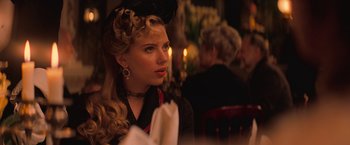 Movie still from “The Prestige” (2006), directed by Christopher Nolan – A woman sitting at a table in front of candles; Close Up shot, Over the shoulder angle