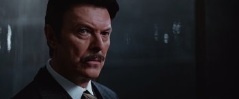 Movie still from “The Prestige” (2006), directed by Christopher Nolan – A person wearing a suit and tie; Close Up shot, Over the shoulder angle