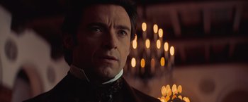 Movie still from “The Prestige” (2006), directed by Christopher Nolan – A person wearing a suit and tie; Close Up shot, Low angle