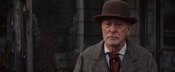Movie still from “The Prestige” (2006), directed by Christopher Nolan – An older man wearing a hat and a tie; Close Up shot, Over the shoulder angle