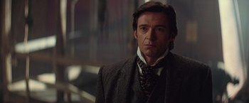 Movie still from “The Prestige” (2006), directed by Christopher Nolan – A person wearing a suit and tie; Close Up shot, Over the shoulder angle