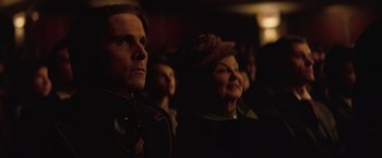 Movie still from “The Prestige” (2006), directed by Christopher Nolan – A group of men and women in a dark room; Close Up shot, Over the shoulder angle