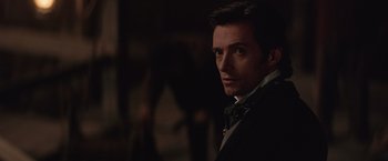 Movie still from “The Prestige” (2006), directed by Christopher Nolan – A person wearing a suit and tie; Close Up shot, Over the shoulder angle
