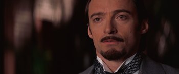 Movie still from “The Prestige” (2006), directed by Christopher Nolan – A person wearing a suit and tie; Close Up shot, Over the shoulder angle