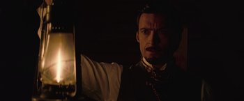 Movie still from “The Prestige” (2006), directed by Christopher Nolan – A person wearing a suit and tie; Close Up shot, Low angle