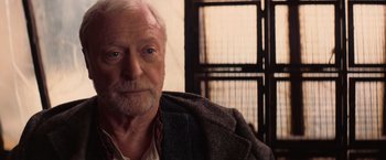 Movie still from “The Prestige” (2006), directed by Christopher Nolan – An older man sitting in front of a window; Close Up shot, Over the shoulder angle