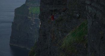 Movie still from “The Princess Bride” (1987), directed by Rob Reiner – A man is hanging from a rope on the side of a cliff; Extreme Wide shot, Overhead angle