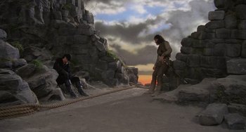 Movie still from “The Princess Bride” (1987), directed by Rob Reiner – Two men are sitting on the rocks near a cliff; Wide shot, Low angle