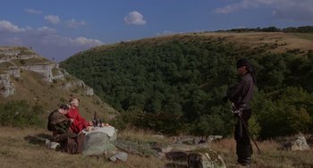 Movie still from “The Princess Bride” (1987), directed by Rob Reiner – Two people sitting in a field with a mountain in the background; Wide shot, Low angle
