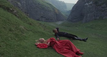 Movie still from “The Princess Bride” (1987), directed by Rob Reiner – A man and a woman laying in the grass near a river; Wide shot, High angle