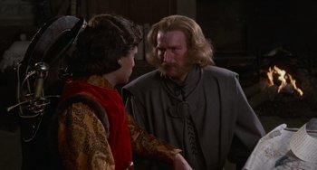 Movie still from “The Princess Bride” (1987), directed by Rob Reiner – A man with long hair and a beard talking to a young man; Medium shot, Over the shoulder angle