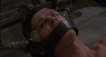 Movie still from “The Princess Bride” (1987), directed by Rob Reiner – A man with his head bandaged up and wearing headphones; Close Up shot, High angle