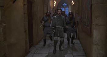 Movie still from “The Princess Bride” (1987), directed by Rob Reiner – A group of men dressed in medieval clothing walking down a hall way; Wide shot, High angle