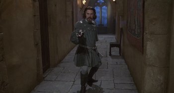 Movie still from “The Princess Bride” (1987), directed by Rob Reiner – A man dressed in medieval clothing holding a gun; Wide shot, Low angle
