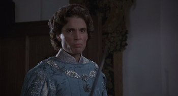 Movie still from “The Princess Bride” (1987), directed by Rob Reiner – A man in a blue suit holding a sword in a room; Close Up shot, Over the shoulder angle