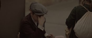 Movie still from “The Railway Children Return” (2022), directed by Morgan Matthews – A man sitting down with his head resting on his hand; Close Up shot, Over the shoulder angle