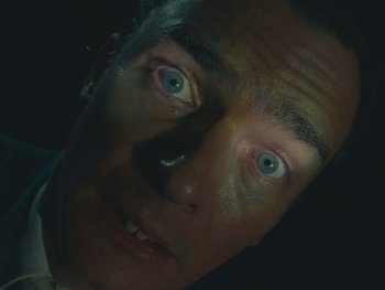 Movie still from “The Rat Catcher” (2023), directed by Wes Anderson – A man's face with blue eyes; Extreme Close Up shot, Low angle