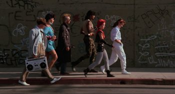 Movie still from “The Return of the Living Dead” (1985), directed by Dan O'Bannon – A group of people walking down a street; Wide shot, High angle