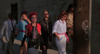 Movie still from “The Return of the Living Dead” (1985), directed by Dan O'Bannon – A group of people standing next to each other on a sidewalk; Medium shot, Low angle