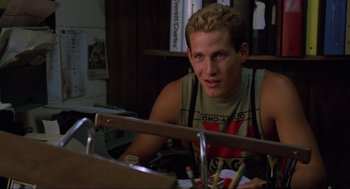 Movie still from “The Return of the Living Dead” (1985), directed by Dan O'Bannon – A man sitting in front of a table with pencils on top of it; Close Up shot, Over the shoulder angle