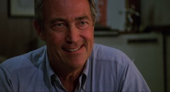 Movie still from “The Return of the Living Dead” (1985), directed by Dan O'Bannon – A man smiling for the camera; Close Up shot, Low angle