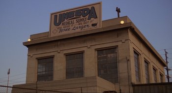 Movie still from “The Return of the Living Dead” (1985), directed by Dan O'Bannon – A large sign on the side of a large building; Extreme Wide shot, Low angle
