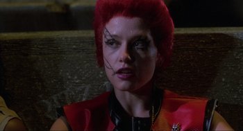 Movie still from “The Return of the Living Dead” (1985), directed by Dan O'Bannon – A woman with red hair and a face tattoo; Close Up shot, Over the shoulder angle
