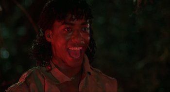 Movie still from “The Return of the Living Dead” (1985), directed by Dan O'Bannon – A man with long black hair is sticking out his tongue; Close Up shot, Low angle