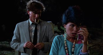 Movie still from “The Return of the Living Dead” (1985), directed by Dan O'Bannon – A man smoking a cigarette in front of a woman; Medium shot, Over the shoulder angle