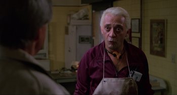 Movie still from “The Return of the Living Dead” (1985), directed by Dan O'Bannon – An older man wearing an apron in a kitchen; Close Up shot, Over the shoulder angle
