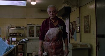 Movie still from “The Return of the Living Dead” (1985), directed by Dan O'Bannon – An older man wearing an apron in a kitchen; Medium shot, Low angle