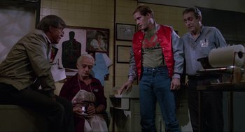 Movie still from “The Return of the Living Dead” (1985), directed by Dan O'Bannon – A group of people standing in a room; Medium shot, Over the shoulder angle