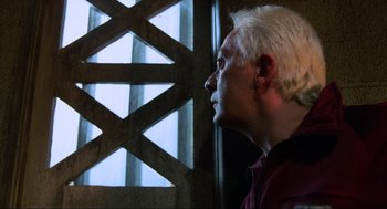 Movie still from “The Return of the Living Dead” (1985), directed by Dan O'Bannon – A man with white hair looking out of a window; Close Up shot, Over the shoulder angle