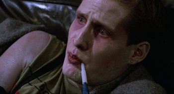Movie still from “The Return of the Living Dead” (1985), directed by Dan O'Bannon – A person with a toothbrush in his mouth; Close Up shot, Low angle