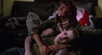 Movie still from “The Return of the Living Dead” (1985), directed by Dan O'Bannon – A woman and a young boy laying on a couch; Medium shot, High angle