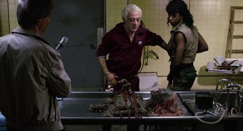 Movie still from “The Return of the Living Dead” (1985), directed by Dan O'Bannon – A man and a woman standing next to a dead animal; Medium shot, Over the shoulder angle