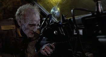 Movie still from “The Return of the Living Dead” (1985), directed by Dan O'Bannon – An old man in a car holding a cell phone; Close Up shot, Over the shoulder angle