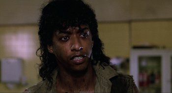 Movie still from “The Return of the Living Dead” (1985), directed by Dan O'Bannon – A man with long black hair is crying; Close Up shot, Low angle