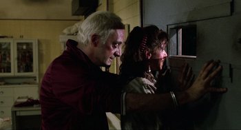 Movie still from “The Return of the Living Dead” (1985), directed by Dan O'Bannon – A man and a woman looking at something in a window; Close Up shot, Low angle