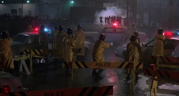 Movie still from “The Return of the Living Dead” (1985), directed by Dan O'Bannon – A group of people standing in the rain next to a fire hydrant; Extreme Wide shot, High angle