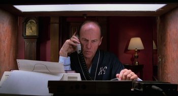 Movie still from “The Return of the Living Dead” (1985), directed by Dan O'Bannon – A man sitting in front of a computer talking on a phone; Medium shot, Low angle