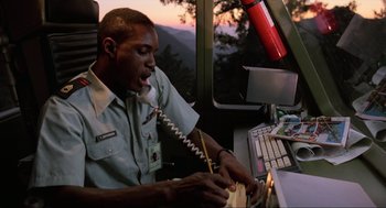 Movie still from “The Return of the Living Dead” (1985), directed by Dan O'Bannon – A man sitting in front of a computer on top of a desk; Medium shot, Low angle
