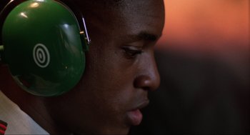 Movie still from “The Return of the Living Dead” (1985), directed by Dan O'Bannon – A person wearing a green ear muffs; Close Up shot, Low angle