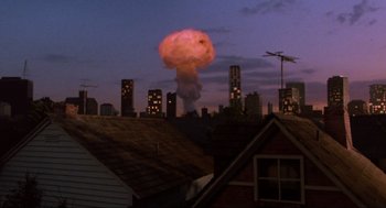 Movie still from “The Return of the Living Dead” (1985), directed by Dan O'Bannon – A mushroom cloud is seen in the sky over a city; Extreme Wide shot, High angle