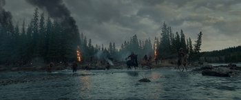 Movie still from “The Revenant” (2015), directed by Alejandro G. Iñárritu – A group of people riding horses across a body of water; Extreme Wide shot, High angle
