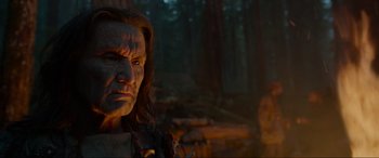 Movie still from “The Revenant” (2015), directed by Alejandro G. Iñárritu – A man with a long hair is standing in the woods; Close Up shot, Low angle