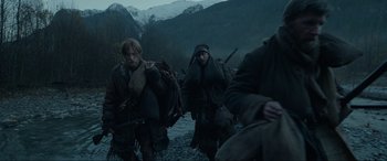 Movie still from “The Revenant” (2015), directed by Alejandro G. Iñárritu – A group of men walking across a river at night; Wide shot, Low angle