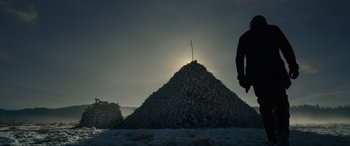 Movie still from “The Revenant” (2015), directed by Alejandro G. Iñárritu – A man standing in front of a pile of leaves; Extreme Wide shot, Low angle