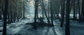 Movie still from “The Revenant” (2015), directed by Alejandro G. Iñárritu – A man sitting in the middle of a forest; Wide shot, High angle